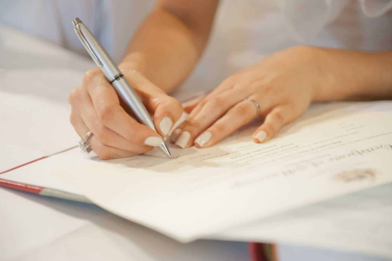 women signing marriage certificate/documents